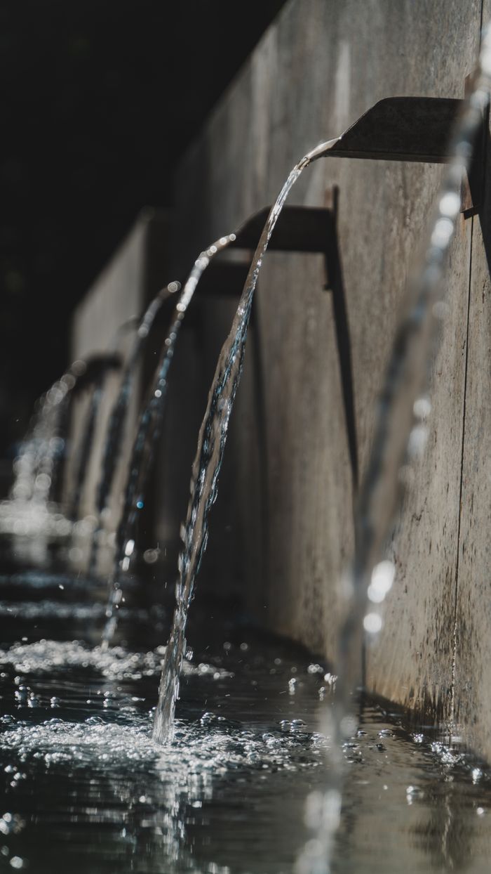 about-us Close-up view of cascading water streams from a fountain on a sunny day.