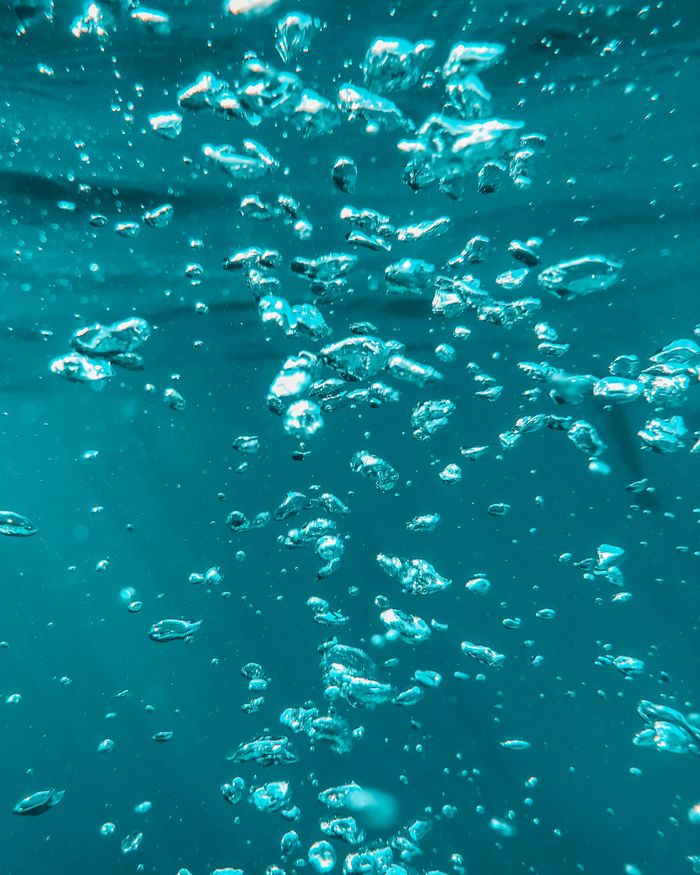 services-06 Beautiful underwater shot capturing bubbles rising in clear blue water, evoking calm and serenity.